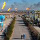 Workers walk in the Nihran Bin Omar field north near Basra, Iraq.